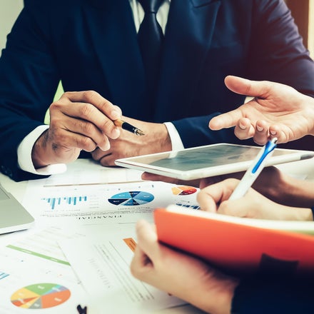 people analyzing business documents around a table